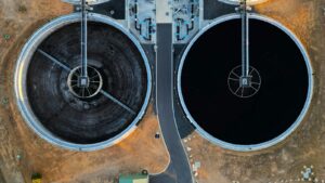 Flygfoto av stora runda bassänger vid ett vattenreningsverk, illustrationsbild