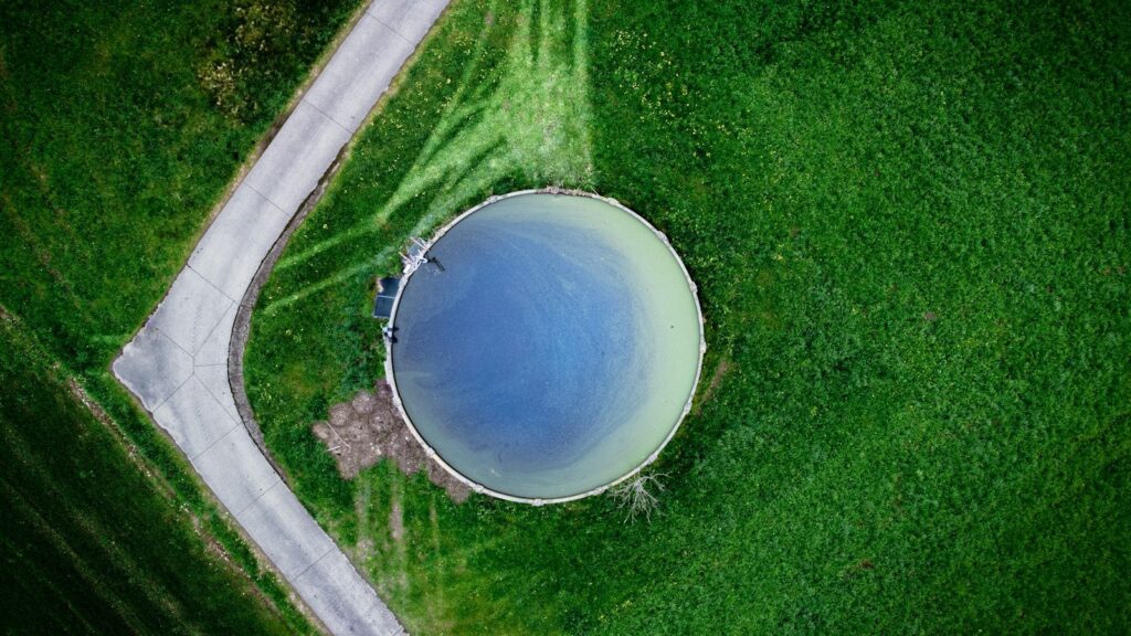 Flygfoto uppifrån av en rund vattenreservoar omgiven av grönska