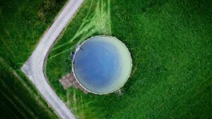 Flygfoto uppifrån av en rund vattenreservoar omgiven av grönska